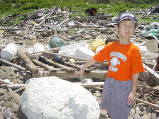 boy pointing at styrofoam on the beach
